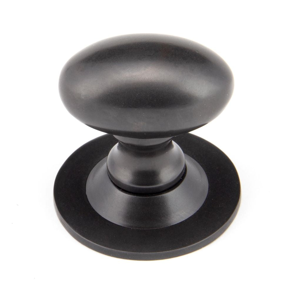 This is an image showing From The Anvil - Aged Bronze Oval Cabinet Knob 33mm available from trade door handles, quick delivery and discounted prices