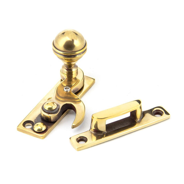 This is an image showing From The Anvil - Aged Brass Prestbury Sash Hook Fastener available from trade door handles, quick delivery and discounted prices