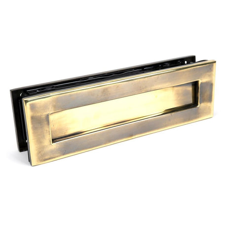 This is an image showing From The Anvil - Aged Brass Traditional Letterbox available from trade door handles, quick delivery and discounted prices