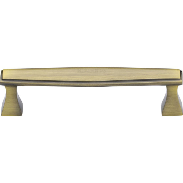 This is an image of a Heritage Brass - Cabinet Pull Deco Design 128mm CTC Antique Brass Finish, c0334-128-at that is available to order from Trade Door Handles in Kendal.