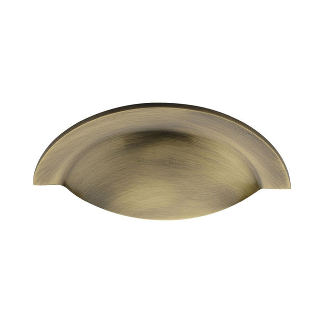 This is a image of a Heritage Brass - Drawer Cup Pull Crescent Design Ant. Brass Finish that is available to order from Trade Door Handles in Kendal