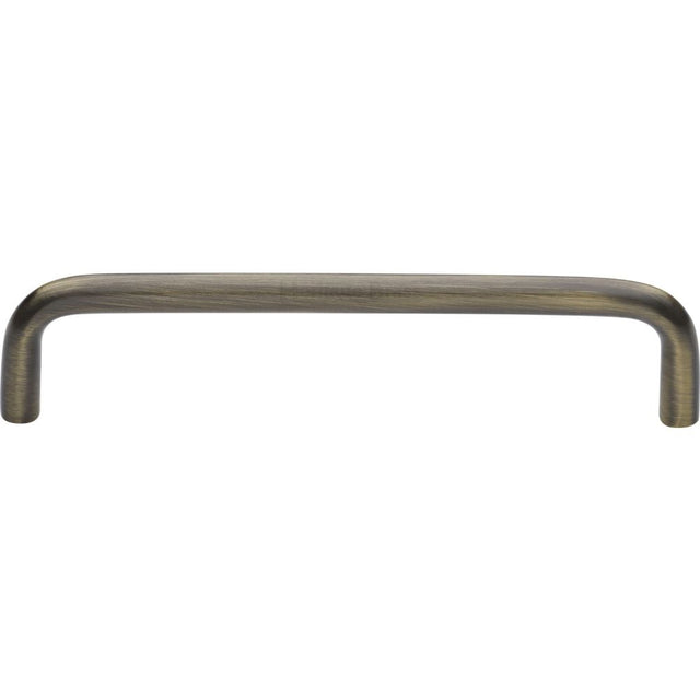 This is an image of a Heritage Brass - Cabinet Pull Wire Design 128mm CTC Antique Brass Finish, c2155-128-at that is available to order from Trade Door Handles in Kendal.