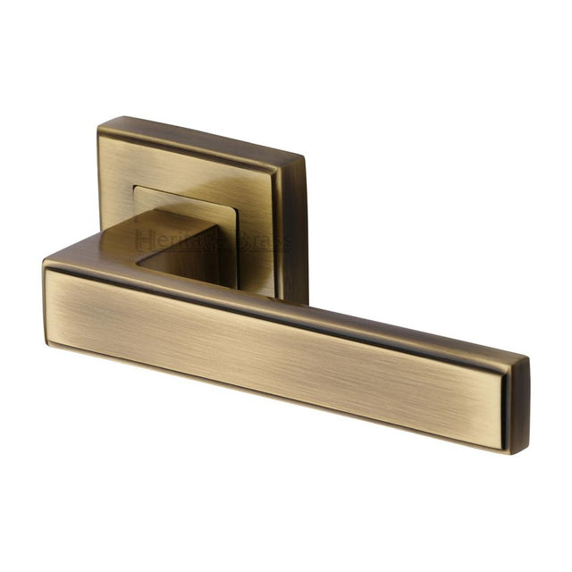 This is an image of a Heritage Brass - Door Handle Lever Latch on Square Rose Linear SQ Design Antique Br, dec5430-at that is available to order from Trade Door Handles in Kendal.