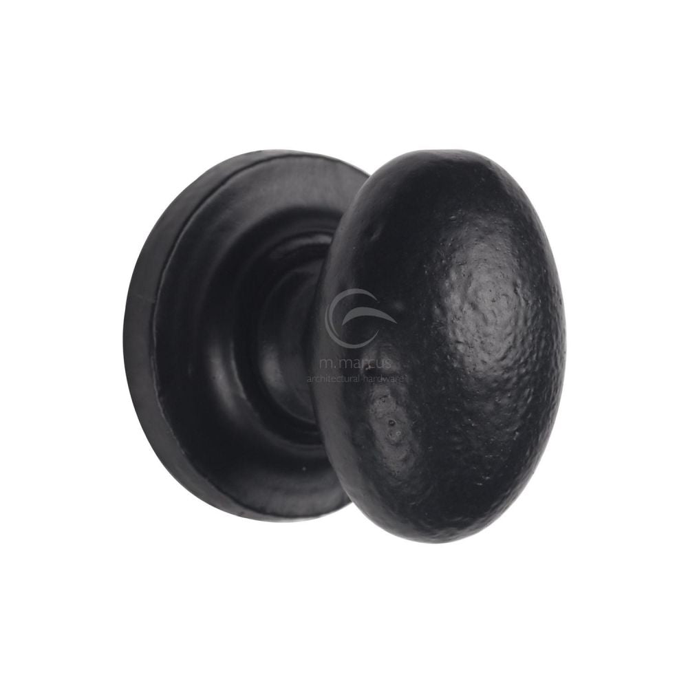 This is an image of a M.Marcus - Black Iron Rustic Cabinet Knob on Round Plate Oval Design 38mm, fb179-38 that is available to order from Trade Door Handles in Kendal.