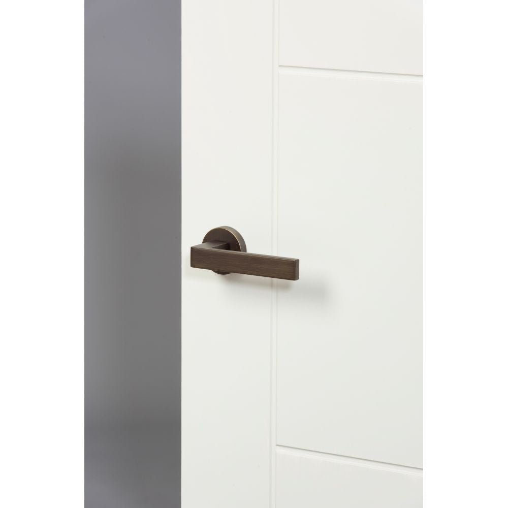 High quality image of Forme Asti Designer Lever on Minimal Round Rose - Urban Bronze | Sku. fmr254ub | available to order from Trade Door Handles in Kendal.