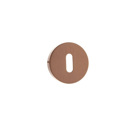 This is an image of Forme Key Escutcheon on Minimal Round Rose - Urban Satin Copper available to order from Trade Door Handles.