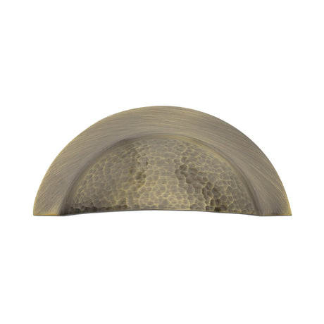 This is an image of a Heritage Brass - Drawer Cup Pull Crescent Hammered Design Antique Brass finish, ham1730-at that is available to order from Trade Door Handles in Kendal.