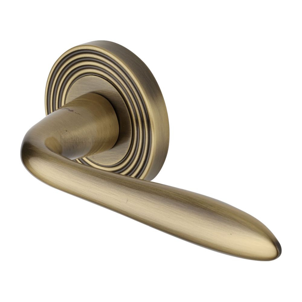 This is an image of a Heritage Brass - Door Handle Lever Latch on Round Rose Sutton Reeded Design Antique, rr1752-at that is available to order from Trade Door Handles in Kendal.