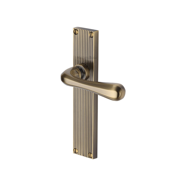 This is an image of a Heritage Brass - Charlbury Reeded Lever Latch Antique Brass finish, rr3010-at that is available to order from Trade Door Handles in Kendal.