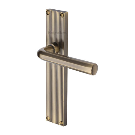 This is an image of a Heritage Brass - Octave Reeded Lever Latch Antique Brass finish, rr3710-at that is available to order from Trade Door Handles in Kendal.