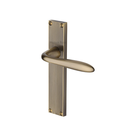 This is an image of a Heritage Brass - Sutton Reeded Lever Latch Antique Brass finish, rr5010-at that is available to order from Trade Door Handles in Kendal.