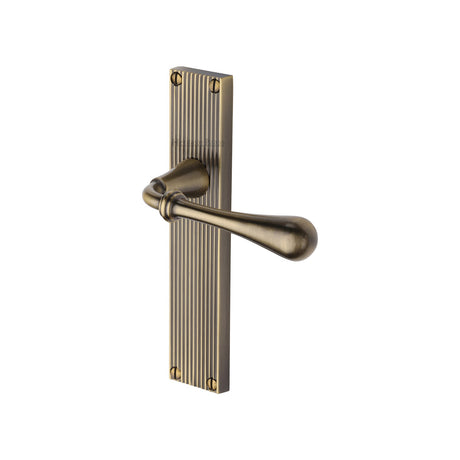 This is an image of a Heritage Brass - Roma Reeded Lever Latch Antique Brass finish, rr6010-at that is available to order from Trade Door Handles in Kendal.