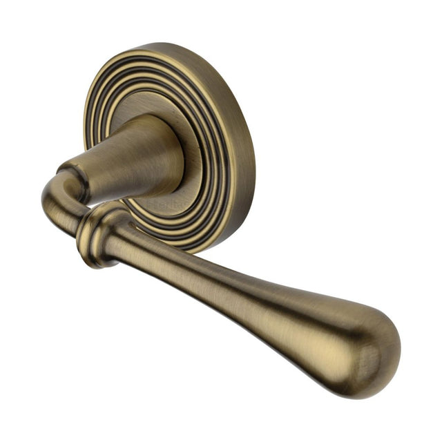 This is an image of a Heritage Brass - Door Handle Lever Latch on Round Rose Roma Reeded Design Antique B, rr7156-at that is available to order from Trade Door Handles in Kendal.