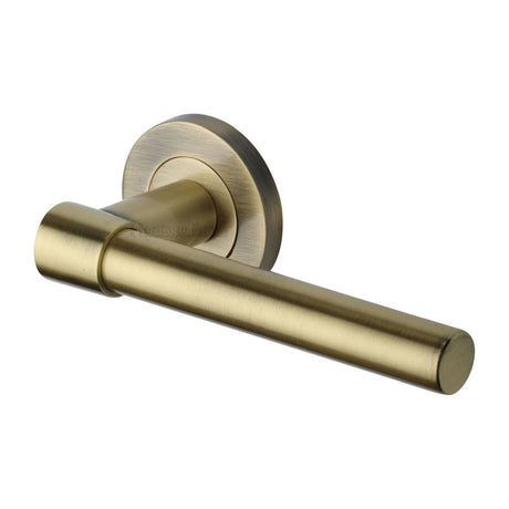 This is an image of a Heritage Brass - Door Handle Lever on Rose Phoenix Design Antique Brass Finish, rs2017-at that is available to order from Trade Door Handles in Kendal.