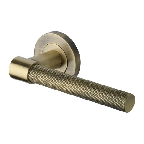 This is an image of a Heritage Brass - Door Handle Lever on Rose Phoenix Knurled Design Antique Brass Fin, rs2018-at that is available to order from Trade Door Handles in Kendal.