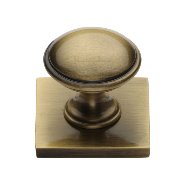 This is an image of a Heritage Brass - Cabinet Knob Domed Design with Square Backplate 32mm Antique Brass, sq3950-at that is available to order from Trade Door Handles in Kendal.