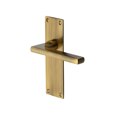 This is an image of a Heritage Brass - Door Handle Lever Latch Trident Design Antique Brass Finish, tri1310-at that is available to order from Trade Door Handles in Kendal.