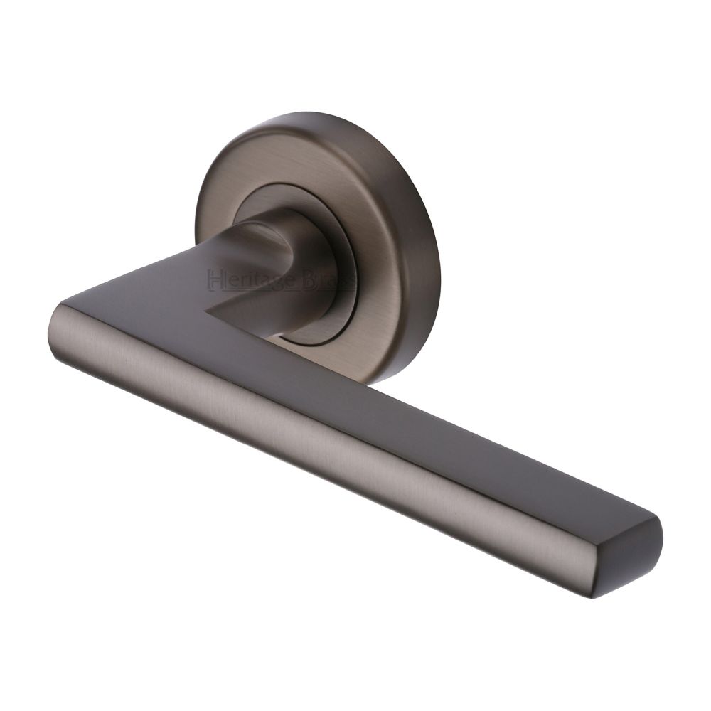 This is an image of a Heritage Brass - Door Handle Lever on Rose Trident Design Matt Bronze Finish, tri1352-mb that is available to order from Trade Door Handles in Kendal.