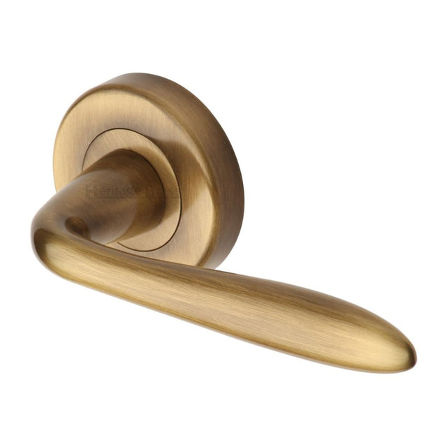 This is an image of a Heritage Brass - Door Handle Lever Latch on Round Rose Sutton Design Antique Brass, v1750-at that is available to order from Trade Door Handles in Kendal.