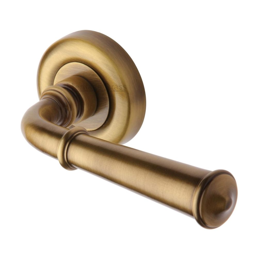 This is an image of a Heritage Brass - Door Handle Lever Latch on Round Rose Colonial Design Antique Bras, v1932-at that is available to order from Trade Door Handles in Kendal.