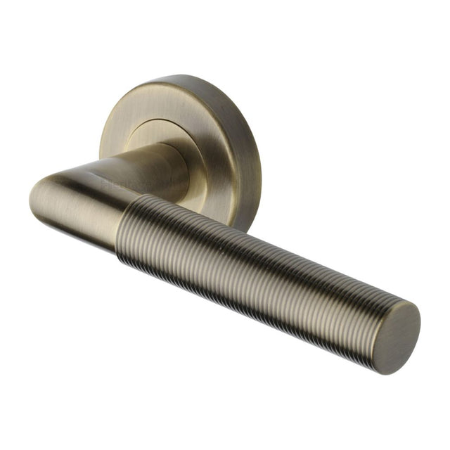 This is an image of a Heritage Brass - Door Handle Lever Latch on Round Rose Bauhaus Mitre Reeded Desi, v2274-at that is available to order from Trade Door Handles in Kendal.