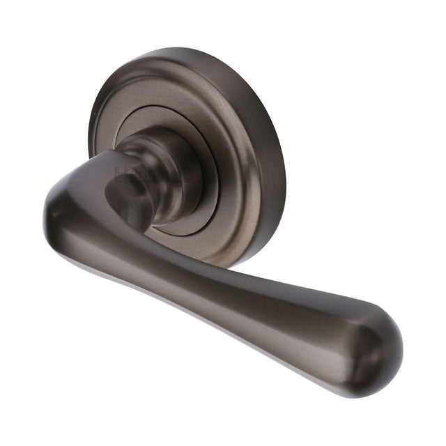 This is an image of a Heritage Brass - Door Handle Lever Latch on Round Rose Charlbury Design Matt Bro, v3020-mb that is available to order from Trade Door Handles in Kendal.