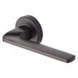 This is an image of a Heritage Brass - Door Handle Lever Latch on Round Rose Metro Angled Design Matt, v3790-mb that is available to order from Trade Door Handles in Kendal.