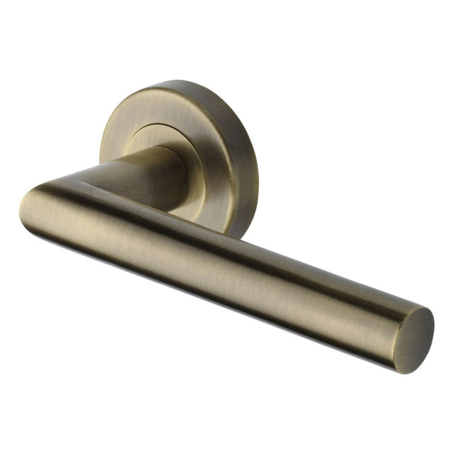 This is an image of a Heritage Brass - Door Handle Lever Latch on Round Rose Athena Design Antique Brass, v3840-at that is available to order from Trade Door Handles in Kendal.