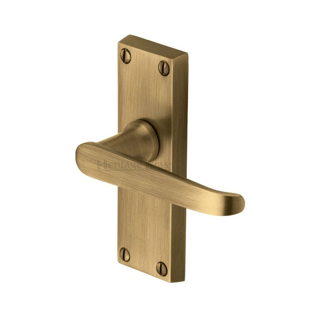 This is an image of a Heritage Brass - Door Handle Lever Latch Victoria Short Design Antique Brass Finish, v3910-at that is available to order from Trade Door Handles in Kendal.