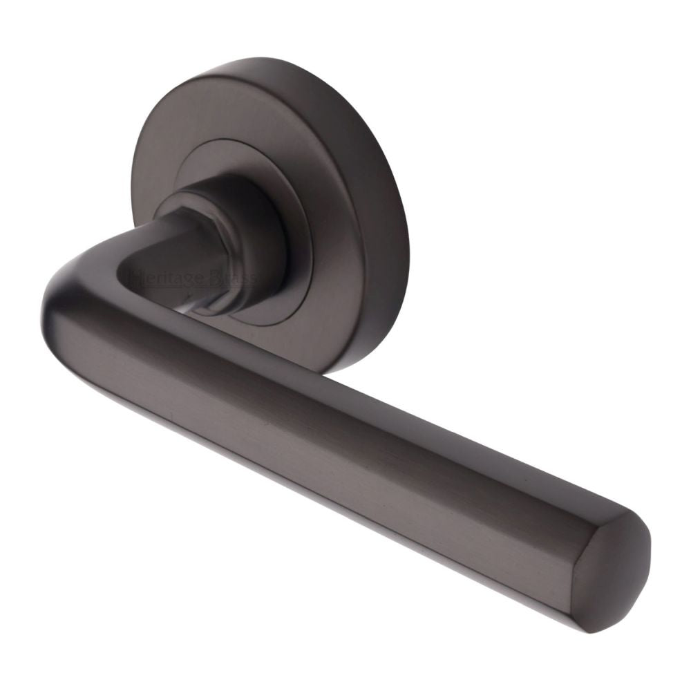 This is an image of a Heritage Brass - Door Handle Lever Latch on Round Rose Octave Design Matt Bronze, v4545-mb that is available to order from Trade Door Handles in Kendal.