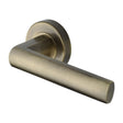 This is an image of a Heritage Brass - Door Handle Lever Latch on Round Rose Poseidon Design Antique Bras, v6230-at that is available to order from Trade Door Handles in Kendal.