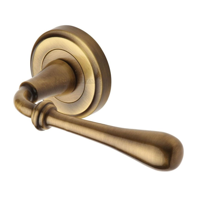 This is an image of a Heritage Brass - Door Handle Lever Latch on Round Rose Roma Design Antique Brass Fi, v7155-at that is available to order from Trade Door Handles in Kendal.