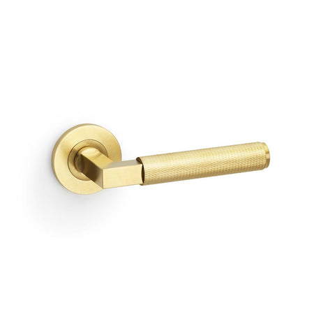 This is an image showing Alexander & Wilks Hurricane Knurled Lever on Round Rose - Satin Brass PVD aw200sbpvd available to order from Trade Door Handles in Kendal, quick delivery and discounted prices.