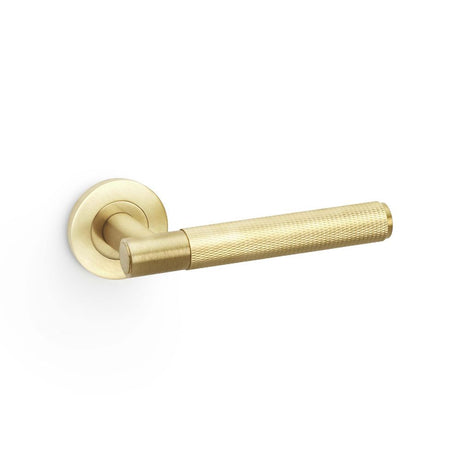 This is an image showing Alexander & Wilks Spitfire Knurled Lever on Round Rose - Satin Brass PVD aw220sbpvd available to order from Trade Door Handles in Kendal, quick delivery and discounted prices.