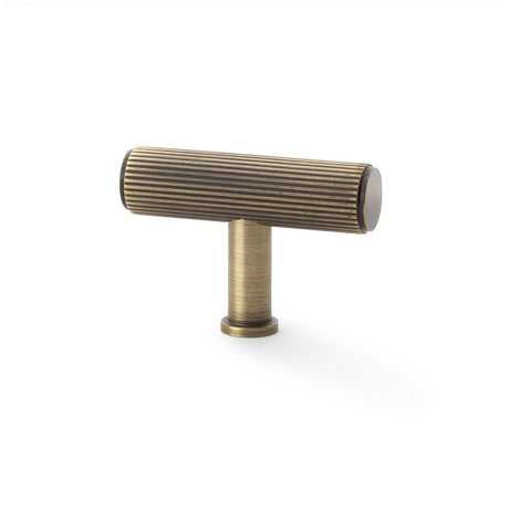 This is an image showing Alexander & Wilks Crispin Reeded T-bar Cupboard Knob - Antique Brass aw801r-55-ab available to order from Trade Door Handles in Kendal, quick delivery and discounted prices.