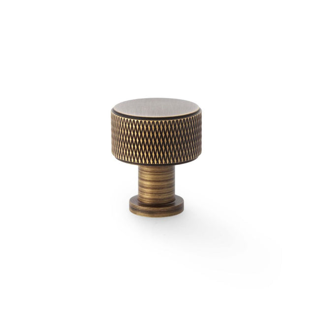 This is an image showing Alexander & Wilks Lucia Knurled Cupboard Knob - Antique Brass - 29mm aw807k-29-ab available to order from Trade Door Handles in Kendal, quick delivery and discounted prices.