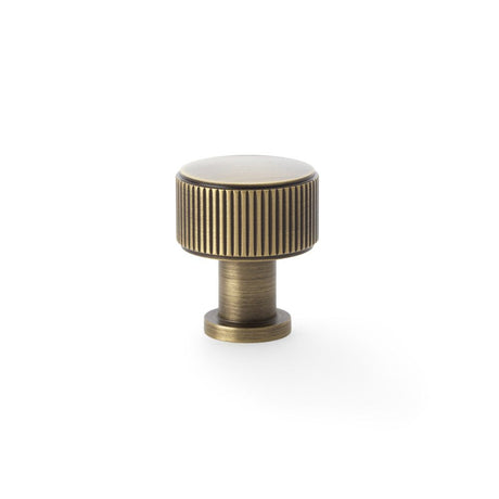 This is an image showing Alexander & Wilks Lucia Reeded Cupboard Knob - Antique Brass - 29mm aw807r-29-ab available to order from Trade Door Handles in Kendal, quick delivery and discounted prices.