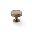 This is an image showing Alexander & Wilks Lynd Cupboard Knob - Antique Brass - 38mm aw808-38-ab available to order from Trade Door Handles in Kendal, quick delivery and discounted prices.