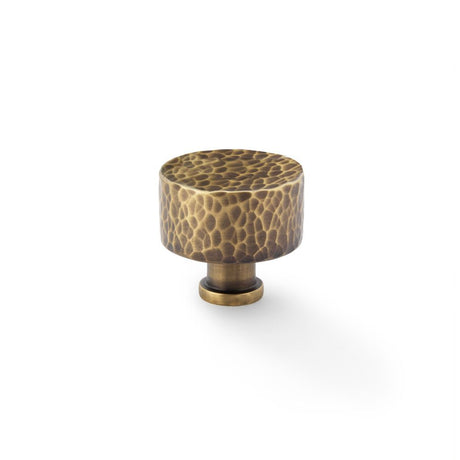 This is an image showing Alexander & Wilks Leila Hammered Cupboard Knob - Antique Brass - 35mm aw816-35-ab available to order from Trade Door Handles in Kendal, quick delivery and discounted prices.