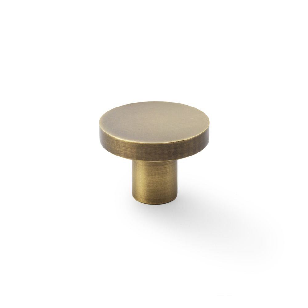 This is an image showing Alexander & Wilks Hanover Plain Cupboard Knob - Antique Brass - Knob 38mm aw821-38-ab available to order from Trade Door Handles in Kendal, quick delivery and discounted prices.