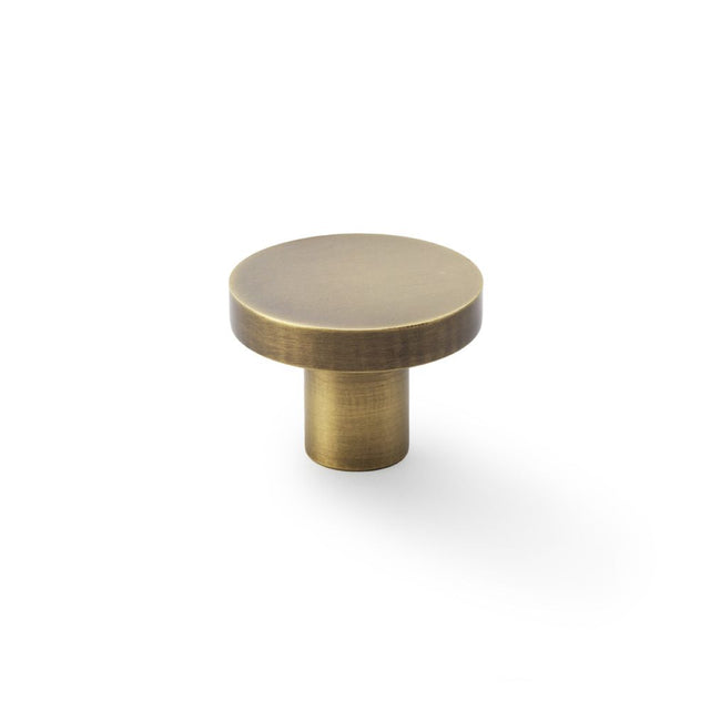 This is an image showing Alexander & Wilks Hanover Plain Cupboard Knob - Antique Brass - Knob 38mm aw821-38-ab available to order from Trade Door Handles in Kendal, quick delivery and discounted prices.