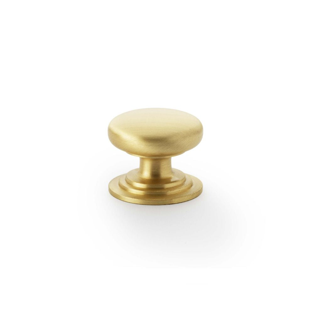 This is an image showing Alexander & Wilks Waltz Round Cupboard Knob on Stepped Rose - Satin Brass - 32mm aw825-32-sb available to order from Trade Door Handles in Kendal, quick delivery and discounted prices.