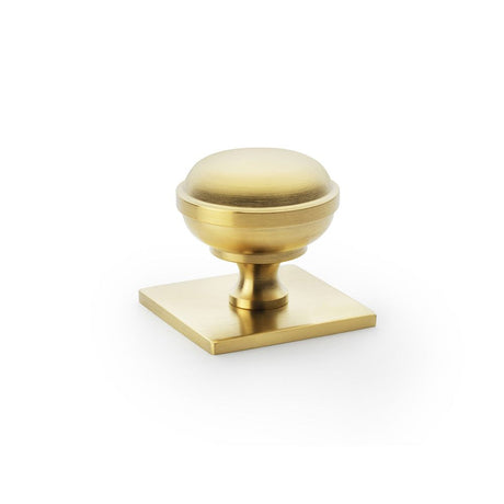 This is an image showing Alexander & Wilks Quantock Cupboard Knob on Square Backplate - Satin Brass PVD - 34mm aw826-34-sbpvd available to order from Trade Door Handles in Kendal, quick delivery and discounted prices.