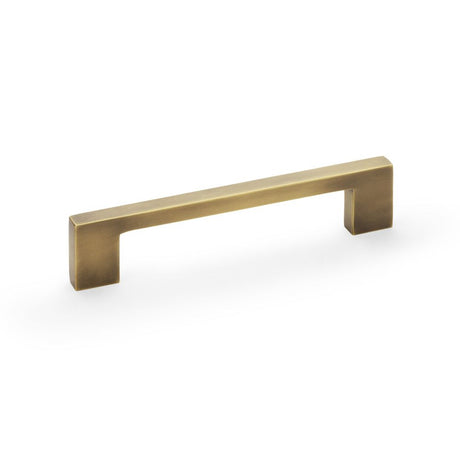 This is an image showing Alexander & Wilks Marco Cupboard Pull Handle - Antique Brass - 128mm aw837-128-ab available to order from Trade Door Handles in Kendal, quick delivery and discounted prices.
