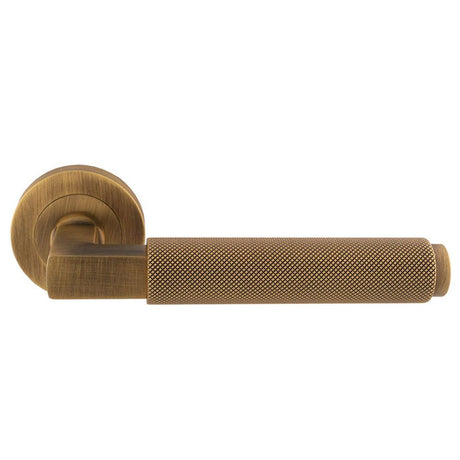 This is an image of a Carlisle Brass - Terazzo Lever On Round Rose - Antique Brass that is availble to order from Trade Door Handles in Kendal.