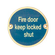 This is an image of a Frelan - Fire Door Keep Locked Shut - Signage 75mm Dia. - Polished Brass that is availble to order from Trade Door Handles in Kendal.