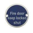 This is an image of a Frelan - Fire Door Keep Locked Shut - Signage 75mm Dia. - Satin Anodised Alumini that is availble to order from Trade Door Handles in Kendal.