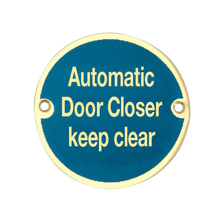 This is an image of a Frelan - Automatic Door Closer Keep Clear - Signage 75mm Dia. - Polished Brass that is availble to order from Trade Door Handles in Kendal.